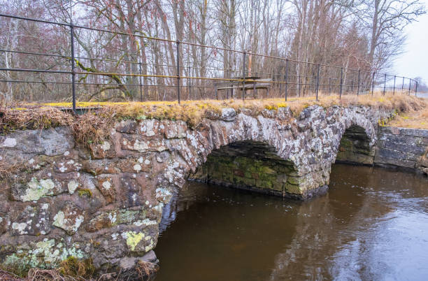 istock Old arch bridge with a rest area over a river 1456146647