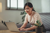 asiatische-frau-genoss-es-am-laptop-zu-hause-im-wohnzimmer-zu-sitzen.jpg?b=1&s=170x170&k=20&c=OAhvfxXoF0NaydyuwSUHiEz7x7szGp0jh0wYdIMb8fY=