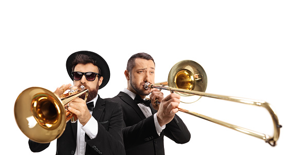 Male musicians playing a trombone and a trumpet isolated on white background