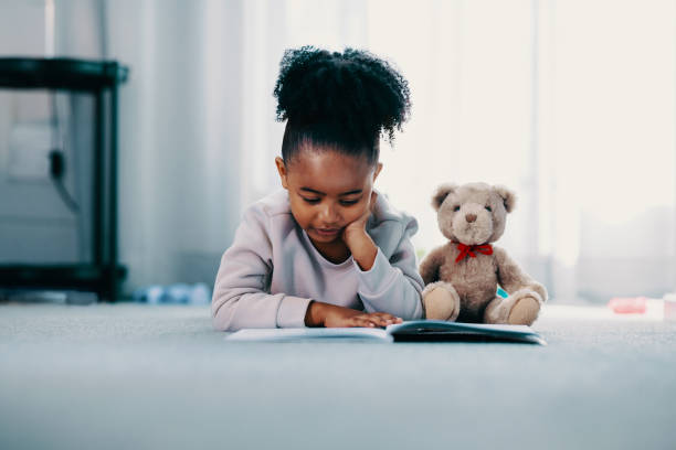 istock Elementary age child reading a book in her bedroom 1456153033