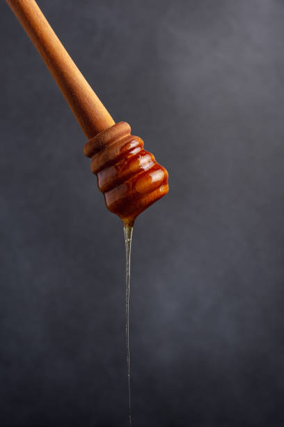 istock Honey pouring with a wooden dipper 1456155240