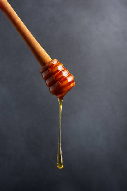 istock Honey pouring with a wooden dipper 1456155248
