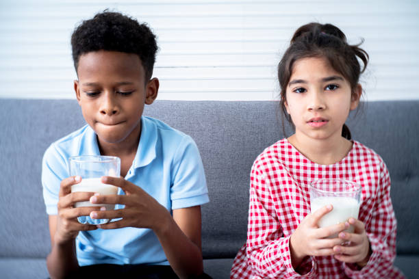 6 year old boy drinking milkshake in home kitchen