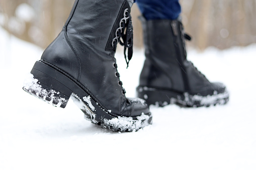 Woman walking on winter street, warm footwear for cold weather