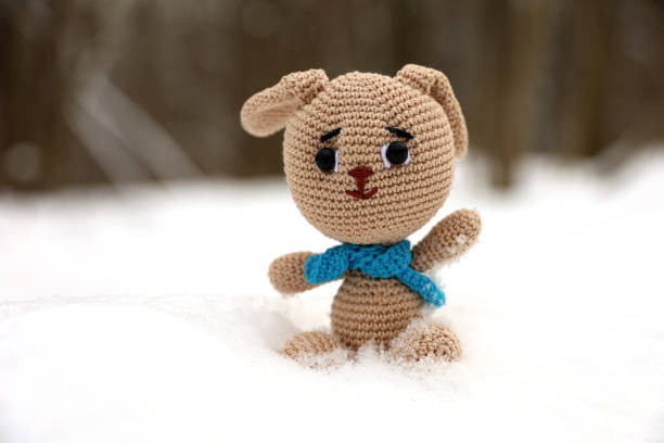 istock Knitted bunny in a snow on blurred forest background, greeting card 1456155503
