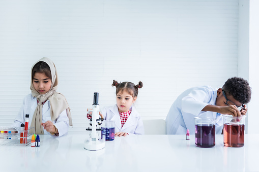 Asian children in the science lab are learning having fun with experiments