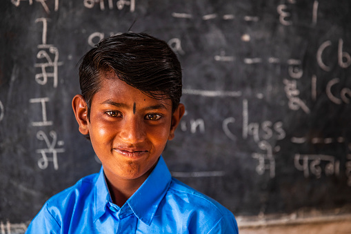 Portrait of Indian schoolboy in classroom, English language class, Rajasthan, India