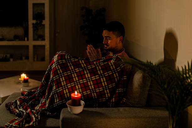 istock A sick man is feeling cold in a dark bedroom during an electric crisis and a blackout. 1456158043