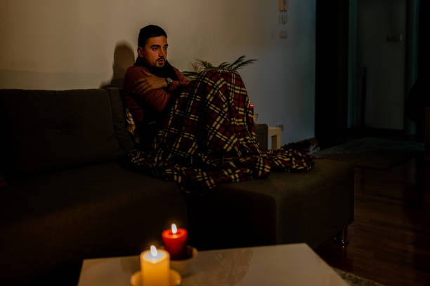 istock A young man with flu is checking his temperature in a dark bedroom during an energetic crisis. 1456158068