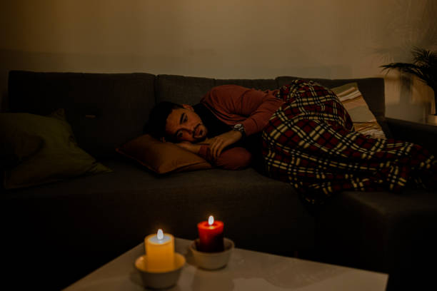 istock During an electricity crisis, a young man with flu is checking his temperature. 1456158104