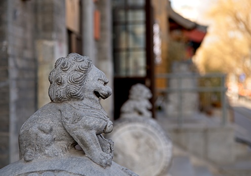 Traditional lion statue stands front of local shop in Beijing. Normally lion statues are always pair, on female and male lion.