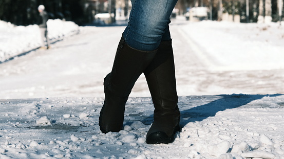 Feet of female tourist is getting frozen on winter street