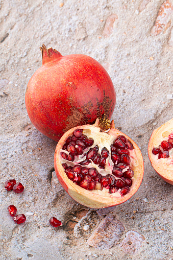 Stock photo showing a close-up, elevated view of healthy eating image of pomegranates (Punica granatum) seeds displaying red flesh (arils) encasing seeds.