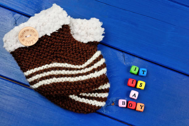 It is a boy words with baby shoes on wooden table