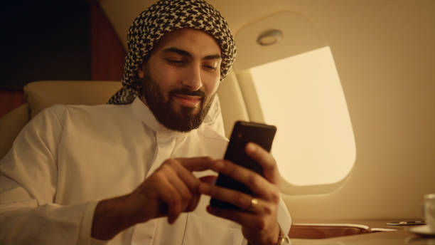 istock Smiling arabian using smartphone closeup. Cheerful man swiping phone in hands 1456166374