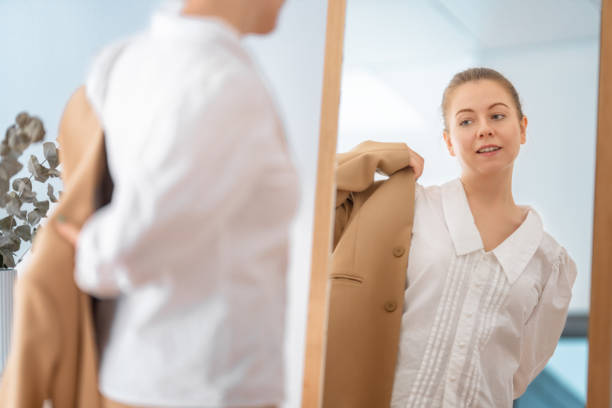 istock woman looking at her reflection in mirror 1456166391