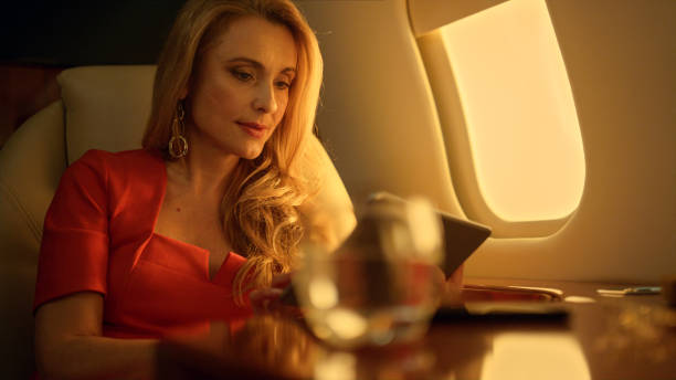 istock Airplane passenger holding tablet computer closeup. Gorgeous businesswoman work 1456172413