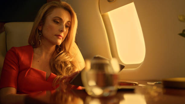 istock Focused ceo working tablet computer on airplane closeup. Boss talk virtual meet 1456172434