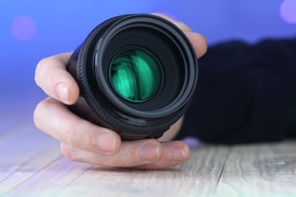 istock 50mm lens in hand on table 1456172624