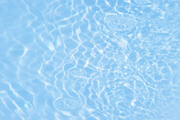 istock Defocus blurred transparent blue colored clear calm water surface texture with splashes and bubbles. Trendy abstract nature background. Water waves in sunlight with caustics. Blue water shinning 1456176466