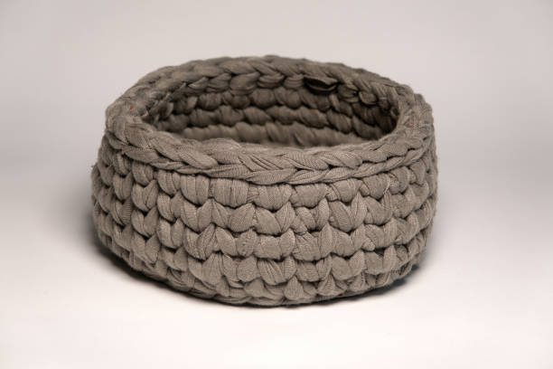 istock Recycling of materials. A small knitted container in gray color is made from fabric strips. For storing small things 1456176501