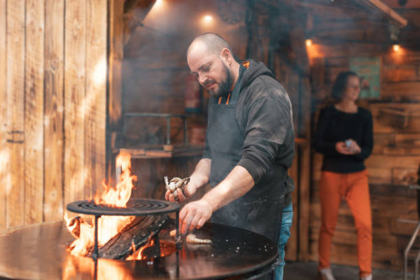 レストランの料理人シェフがバーベキューの火で屋外でエビを調理する - shrimp grilled prepared shrimp barbecue ストックフォトと画像