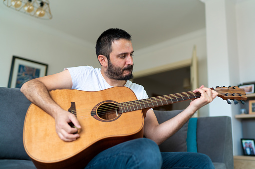 Man at home playing guitar