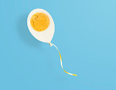 Balloon concept of boiled chicken egg on blue
