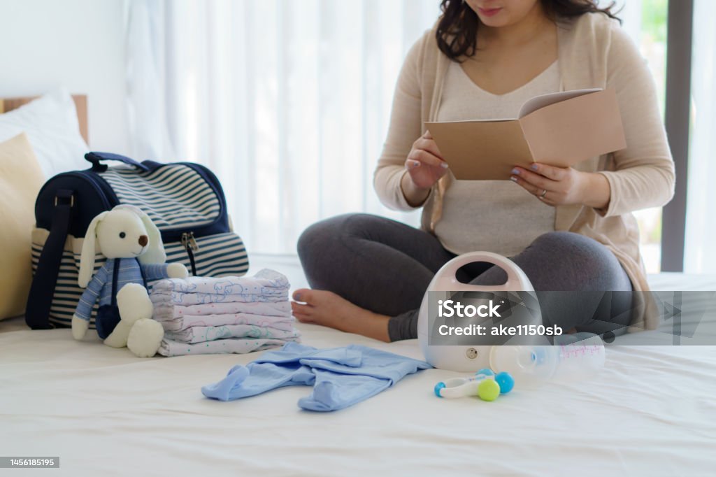 Asian Pregnant woman prenatal calendar planner and baby monitor utensils, container preparation for pregnancy concept. Pregnant Stock Photo