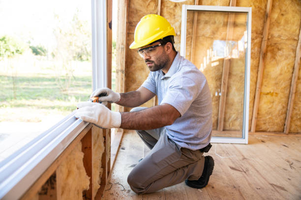 Construction worker installing windows on wooden house stock photo