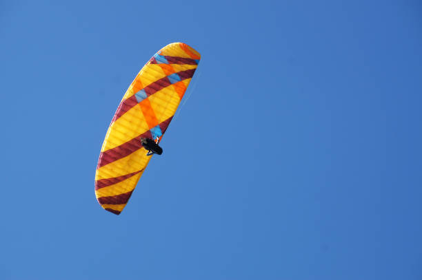 istock a man flies on a paraglider in a clear blue sky close-up 1456185883