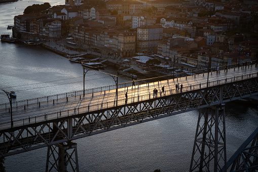 Sunset over the bridge Ponte Dom Luís I and the Ribeira quarter of Porto; Portugal. Unidentifiable People on the bridge