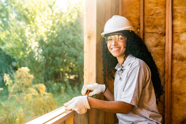 Construction trainee working in wooden house interior