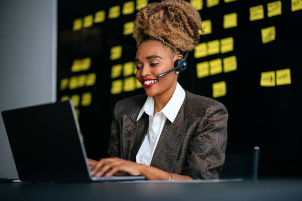 istock Smiling Businesswoman Talking With Customer While Using A Laptop Computer In The Office 1456193164