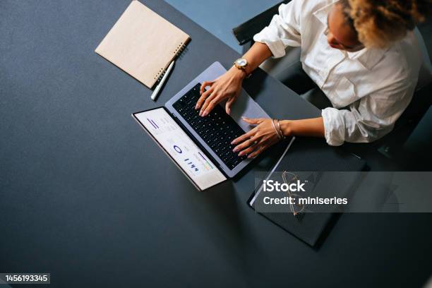 High Angle View Of Unrecognizable Woman Typing Business Report On A Laptop Keyboard In The Cafe Stock Photo - Download Image Now