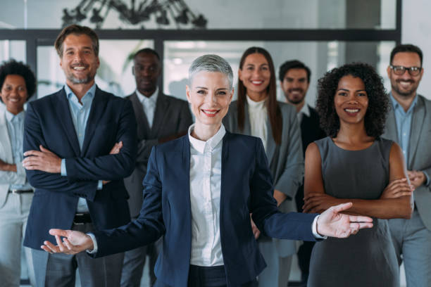 confident businesswoman and her team. - arms outstretched fotos imagens e fotografias de stock