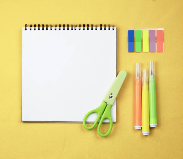 istock School notebook for records on a yellow background with multi -colored markers. 1456196527