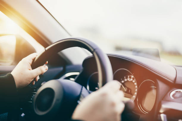 istock Driver hands on steering wheel driving a car 1456197090