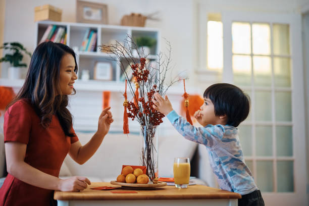 feliz madre e hijo decorando casa para el año nuevo chino. - orange sauce fotografías e imágenes de stock