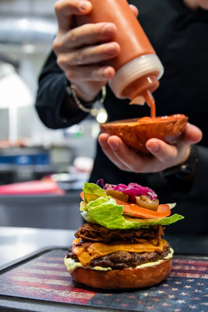 istock chef hand preparing a gourmet burger on restaurant kitchen step by step 1456201589