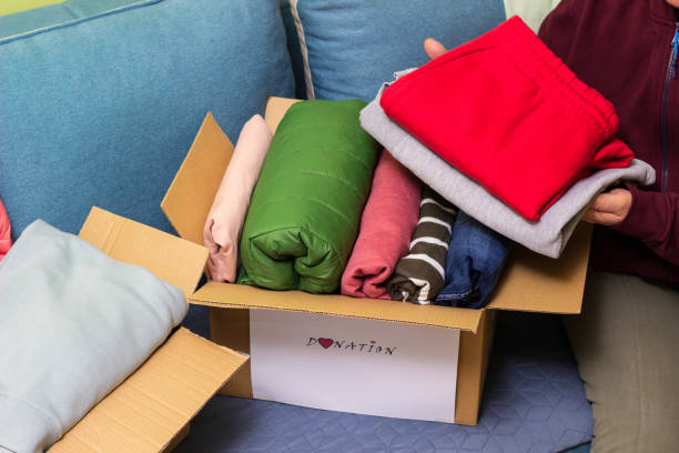 istock Woman holding clothes with Donate Box In her room 1456211694
