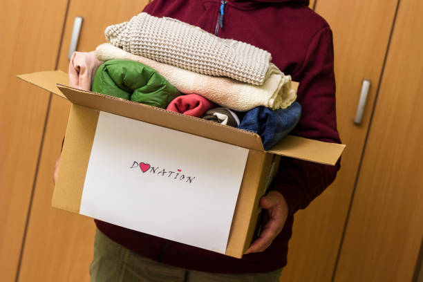istock Woman holding clothes with Donate Box In her room 1456211697
