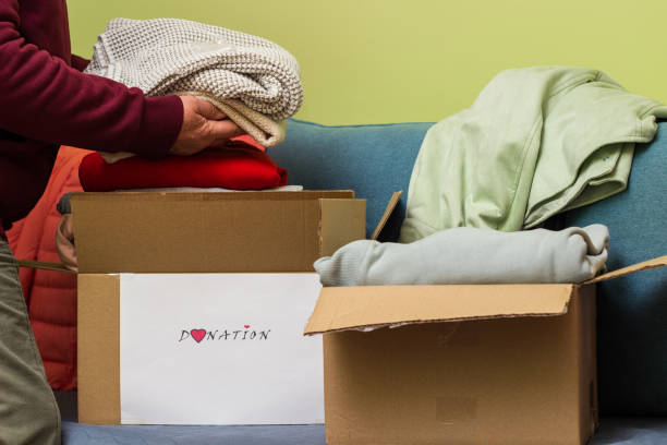 istock Woman holding clothes with Donate Box In her room 1456211796