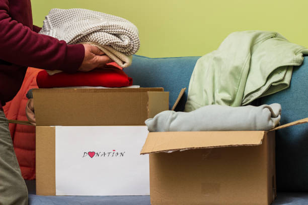 Woman holding clothes with Donate Box In her room stock photo