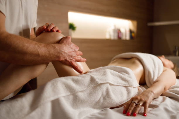 massage anti-cellulite des cuisses dans le salon en gros plan. masseur faisant un massage des jambes à la femme - massage sensuel photos et images de collection