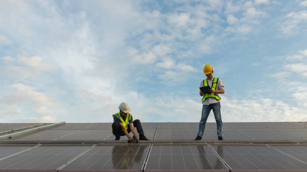 istock Engineer working setup Solar panel at the roof top. Engineer or worker work on solar panels or solar cells on the roof of business building 1456218499