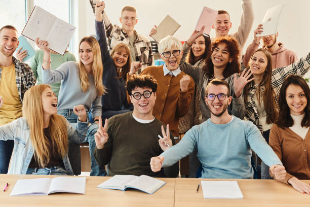 istock Cheerful students and their professor celebrating success in the classroom. 1456218940