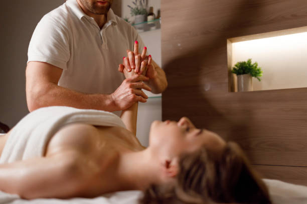 chiropraticien examinant le bras d’une femme - massage therapist massaging sport beautician photos et images de collection