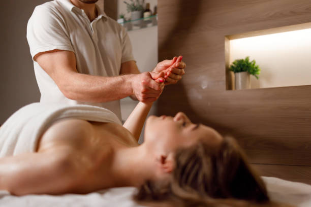 masseur femme s'étirant les bras - massage therapist massaging sport beautician photos et images de collection