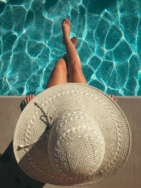 istock Woman wearing large hat sitting poolside 1456221345